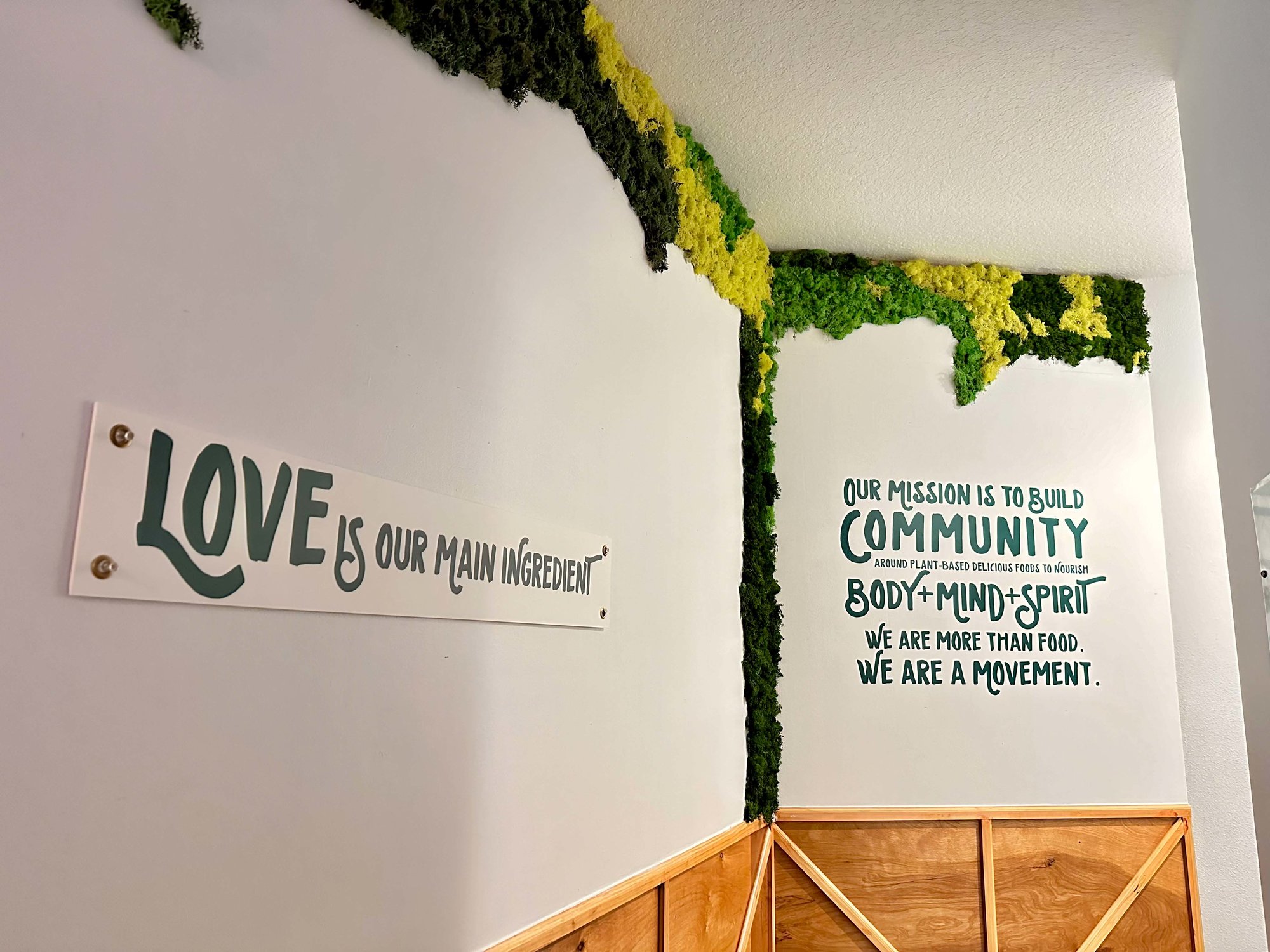 white wall with black text and greenery